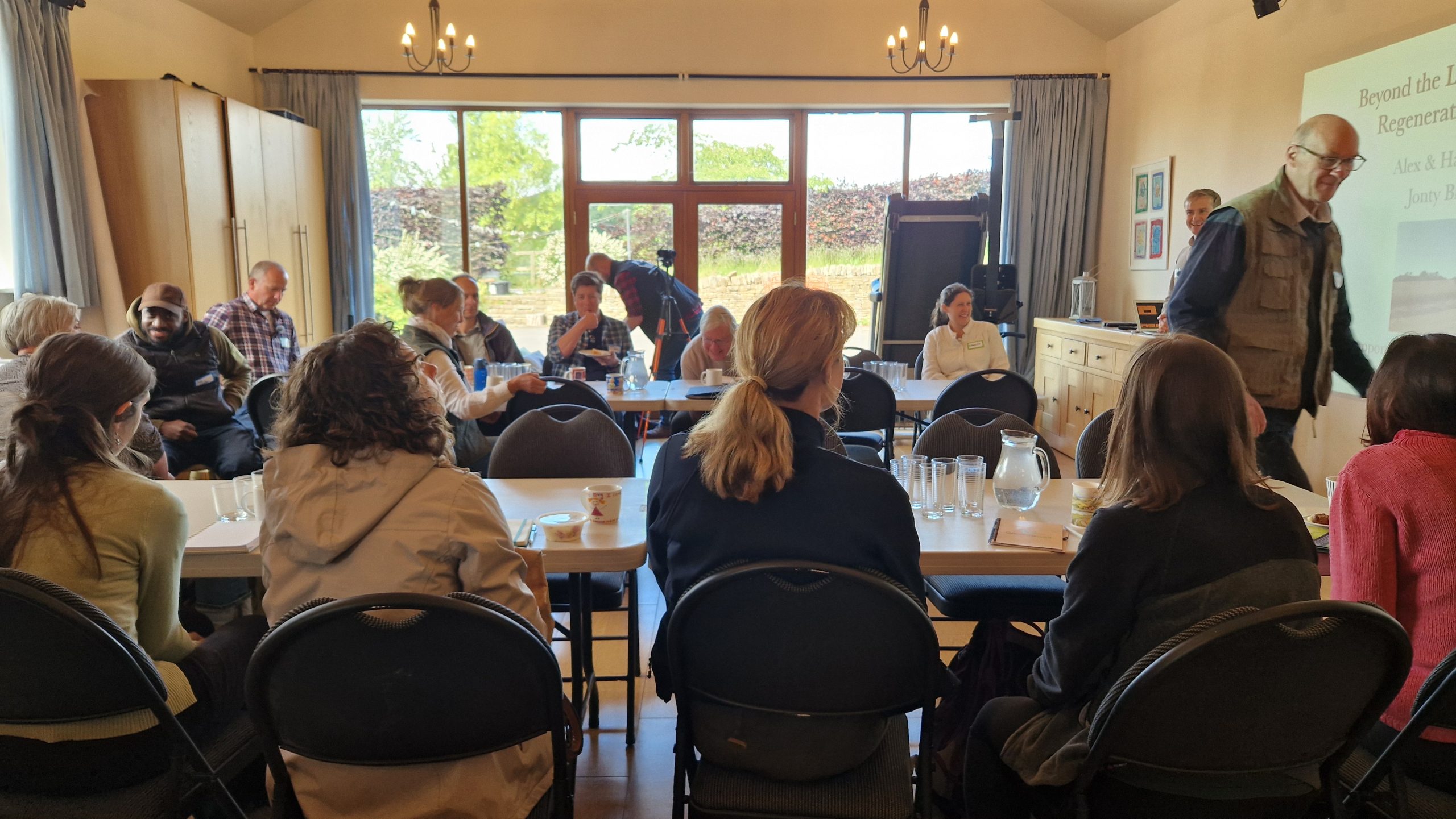 People at tables listening to presentations at Fraser Farms