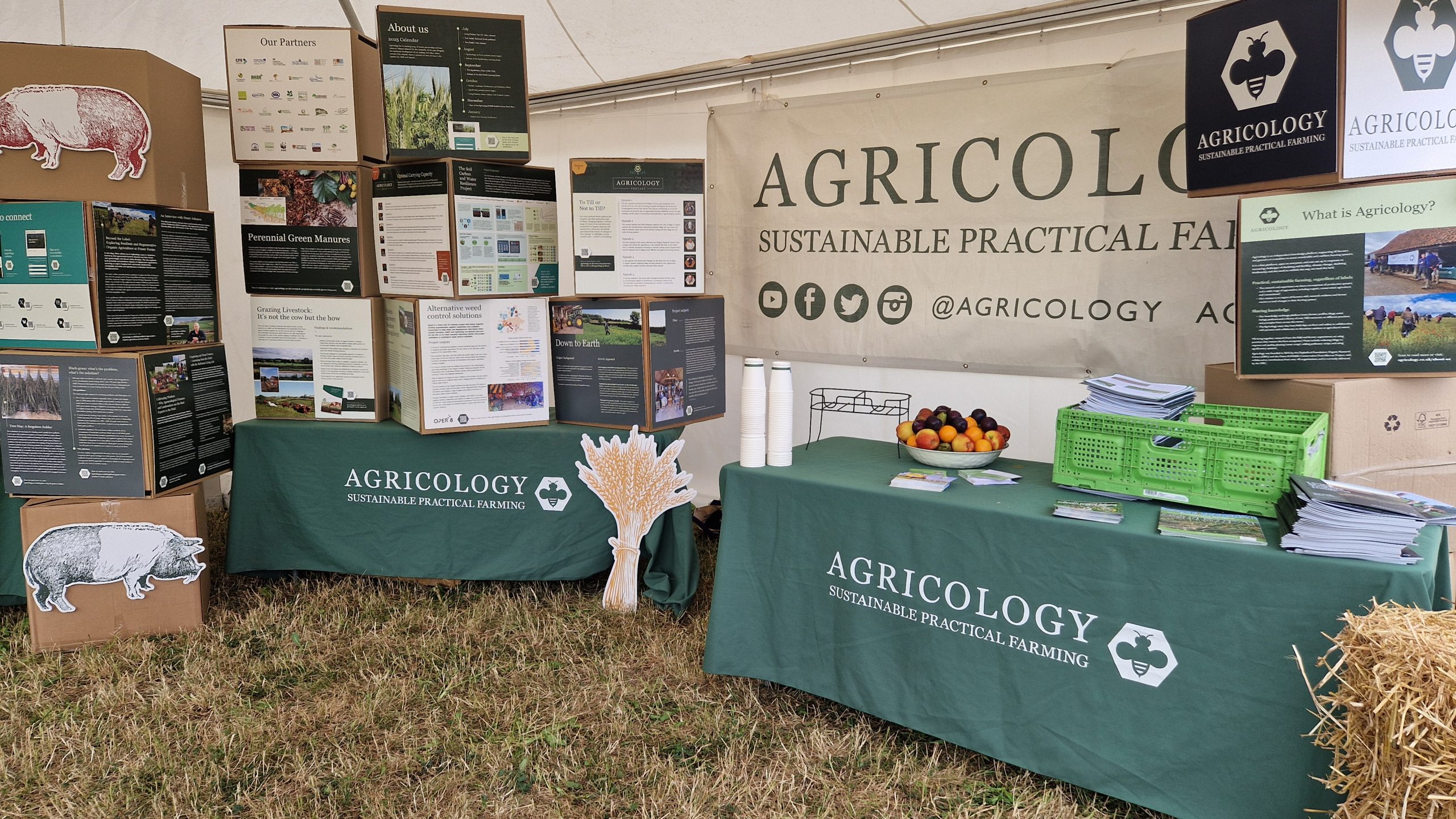 A table, Agricology banner, and boxes with information on them. 