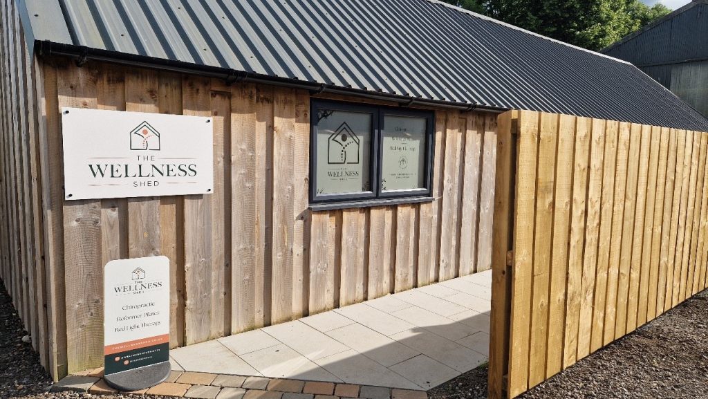 a wooden cabin with a sign for a chiropractor outside