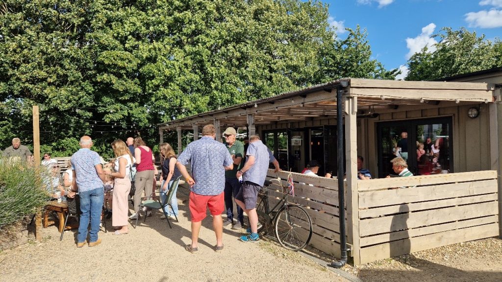 People standing in the sun outside a cafe