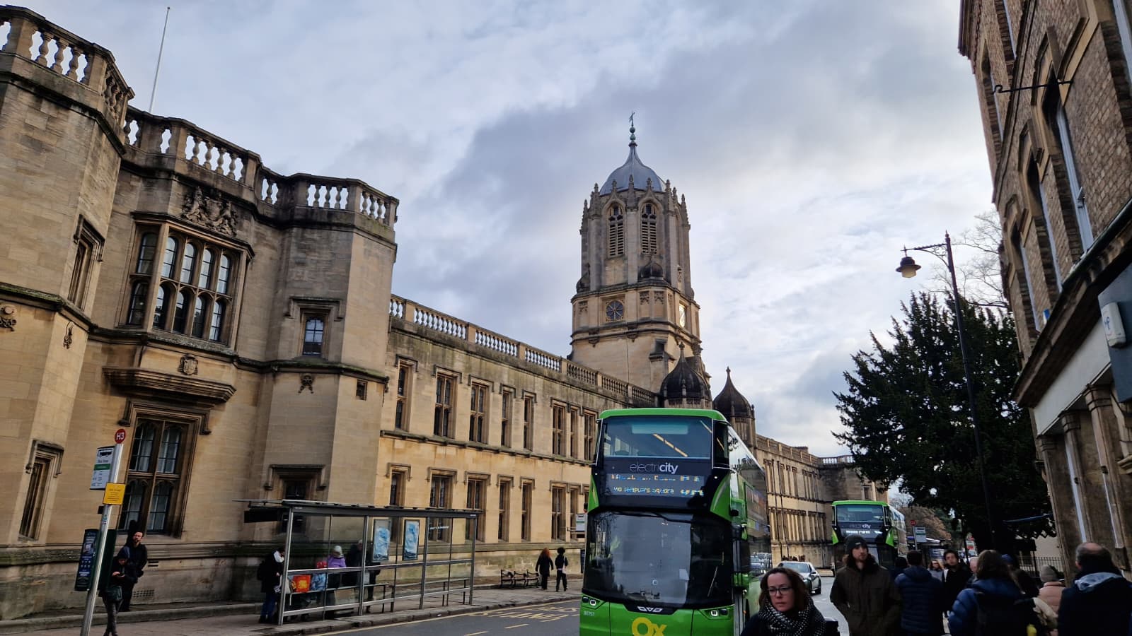 A bus driving up St Aldates in front of Christchurch College in Oxford